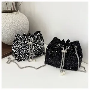 Detailed view of fashionable sequin bucket bags with metal chains and pearl drawstring cords.