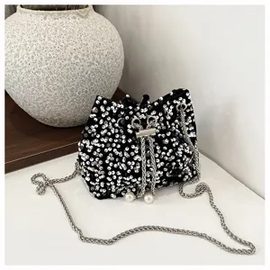 Black sequin bucket bag with metal chain strap and pearl drawstring details for women evening.