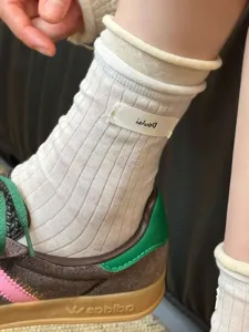 Chaussettes mi-hautes unies blanches côtelées confortables avec revers et étiquette latérale.