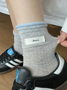 Chaussettes mi-hautes côtelées confortables avec bord roulé et jolie étiquette latérale.