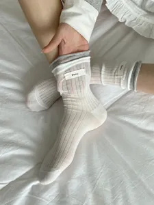 Vue détaillée de chaussettes mi-mollet en tricot ajouré avec ourlet contrasté fin.