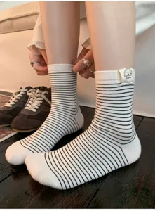 Close-up detail of black and white striped cotton socks featuring a cute puppy tab.