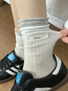 Chaussettes mi-hautes unies côtelées ajourées à revers contrastés avec étiquette en tissu.