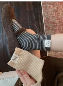 Cute puppy label striped mid-tube socks detail shot, soft cotton material, cozy autumn wear.