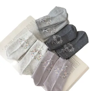 Chaussettes mi-hautes en coton pour femmes avec broderie florale et nœud papillon.