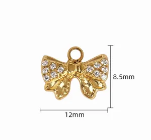 Gold rhinestone bow pendant detail closeup, sparkling crystal DIY jewelry accessory component.
