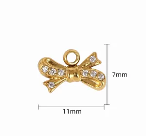 Close-up detail of a gold-plated rhinestone bow pendant, showing precise dimensions and stone inlay.