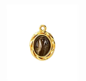 Close-up of a vintage gold-plated oval cat eye stone pendant with a twisted frame detail.