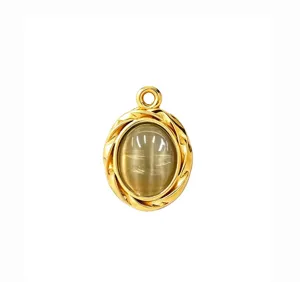 Detailed close-up of oval cat eye stone pendant with gold stainless steel twisted frame design.