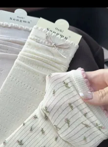 Nahaufnahme von Lolita Schleifensocken, Rippstrick Textur und süßem Blumenmuster.
