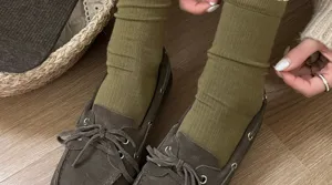 Olive green mid-calf slouch socks close-up view, soft knit fabric for stylish daily outfits.