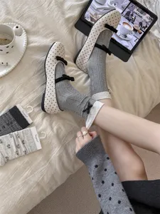 Detailed view of sweet grey stacked socks and polka dot Mary Jane shoes, cozy autumn winter style.