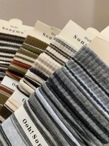 Women's Korean style striped mid-tube socks with paper card packaging, comfortable knit fabric.