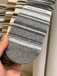 Detail view of women's knitted striped mid-calf socks with paper band packaging, cozy fit.