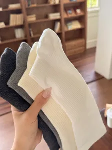 Gros plan de chaussettes hautes côtelées multicolores, texture douce et ajustement idéal.