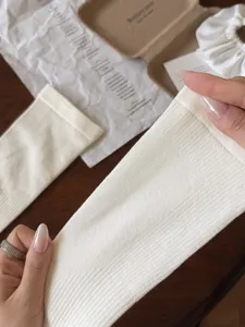 Vue en gros plan montrant la texture tricotée côtelée et l'élasticité des chaussettes de compression.