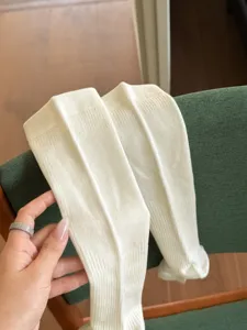 Gros plan de chaussettes hautes côtelées douces couleur crème basique, style décontracté.