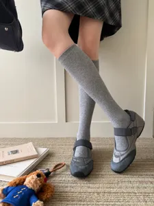 Chaussettes hautes grises en tricot, associées à des baskets mary jane grises.