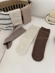 Detail view of retro brown mid-tube socks with lettuce edge and hollow design for autumn winter.