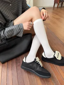 Chaussettes hautes blanches confortables et côtelées pour femmes, idéales en automne.