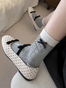 Chic grey women mid-calf socks featuring cute black bows, detailed knit texture design.