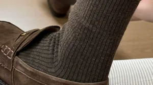 Detail shot of women's ribbed mid-tube socks paired with vintage suede loafers, soft texture.
