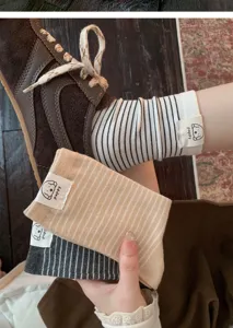 Cute striped mid-tube socks detail view featuring a sweet puppy label and soft cotton texture.