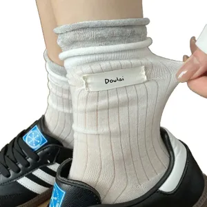 Chaussettes mi-hautes unies et côtelées pour femme avec étiquette latérale et extensible.