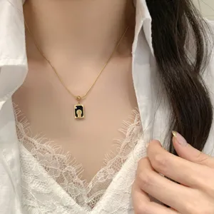 Gros plan détail du collier élégant avec pendentif carré en pierre naturelle de tarot.