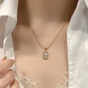 Gros plan détaillé de ce magnifique collier pendentif couronne en nacre carrée plaquée or.