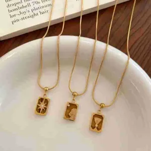 Collier pendentif carte de tarot en acier titane doré avec détails en pierre naturelle.