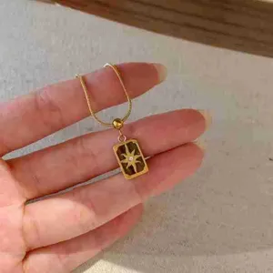 Collier pendentif carte de tarot en acier inoxydable détail avec étoile et pierre géométrique.