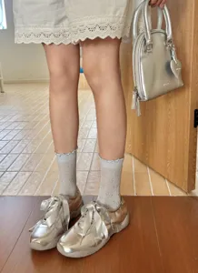 Ruffle mesh bow mid-tube socks paired with stylish silver casual sneakers for women.