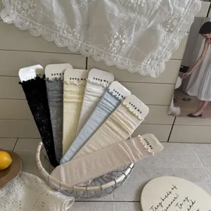 Detailed shot of delicate lace ruffle mid-tube socks in various sweet pastel colors.