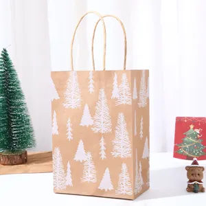 Detail view of Christmas kraft paper gift bag with white tree prints and sturdy handles.