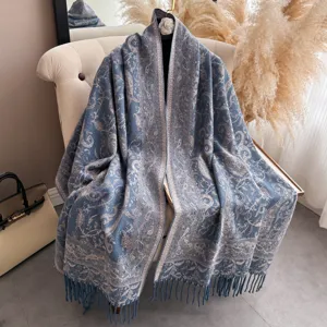 Vista dettagliata dell'elegante scialle lungo in jacquard paisley blu con delicate frange.