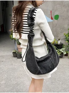 Details of the casual washed denim hobo bag featuring a unique pleated shoulder strap design.