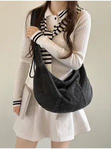 Casual dark denim slouchy hobo bag detail shot, showing large capacity and soft pleated design.