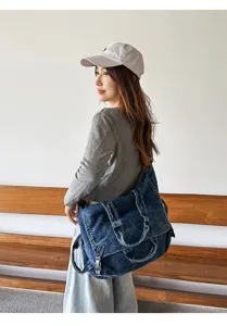 Detailed view of vintage washed denim crossbody bag, large capacity motorcycle style chic.