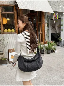 Casual denim shoulder bag detail, large capacity pleated design, soft fabric texture.