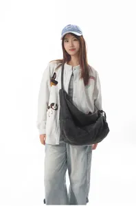 Detailed view of a casual denim crossbody bag showcasing soft fabric and adjustable strap style.
