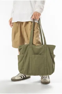 Λεπτομερής όψη vintage πλυμένης τσάντας tote από καμβά με πλαϊνές τσέπες και λουριά.