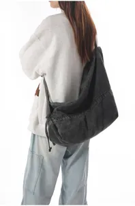 Detail view of the dark grey washed denim hobo crossbody bag showcasing soft texture.