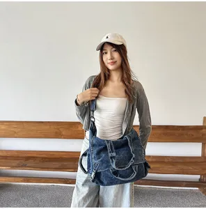 Detailed shot of retro washed denim shoulder bag, showing large capacity and cool style.