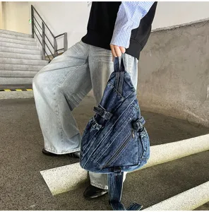 Vintage washed denim sling bag detail showcasing multi-zipper pockets and rugged everyday style.