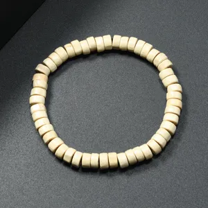 Close-up detail of a minimalist cylindrical wooden bead bracelet, retro ethnic style decor.