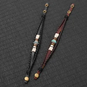 Gros plan de bracelets en cuir tressé faits à la main avec perles, style punk vintage.