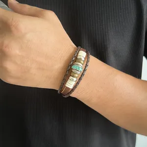 Bracelet en cuir multicouche avec perles de cristal et accents en métal sur le poignet.
