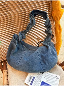 Casual denim shoulder bag with ruched strap and zipper closure, stylish hobo design for daily wear.