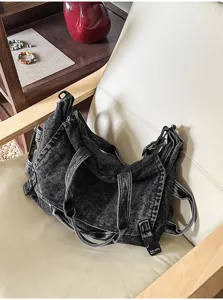 Close-up view of a vintage washed denim handbag, featuring durable canvas and black buckle details.
